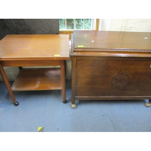 449 - A carved oak linen chest with hinged top on castors, and a mid-century teak foldover tea table with ... 