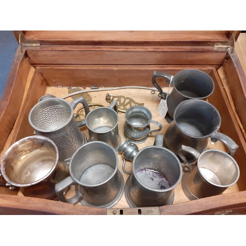 406 - An early 20th century cutlery box and contents to include pewter and silver plated tankards and bras... 