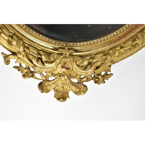 168 - A large 19th century carved and giltwood oval mirror, with pierced acanthus and floral crest, beaded... 