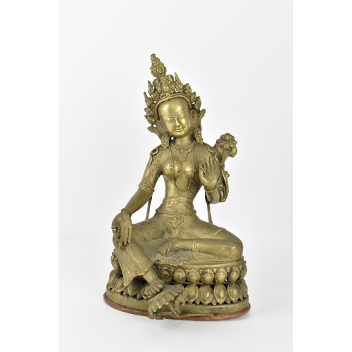 56 - A Sino-Tibetan bronze figure of the Buddha Green Tara, her left hand holding a lotus flower, while t... 