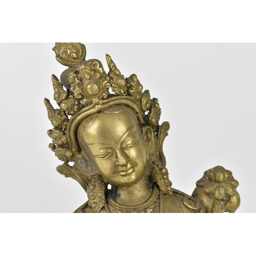 56 - A Sino-Tibetan bronze figure of the Buddha Green Tara, her left hand holding a lotus flower, while t... 