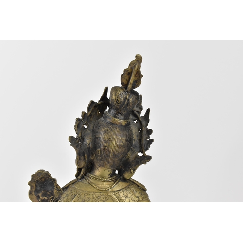 56 - A Sino-Tibetan bronze figure of the Buddha Green Tara, her left hand holding a lotus flower, while t... 