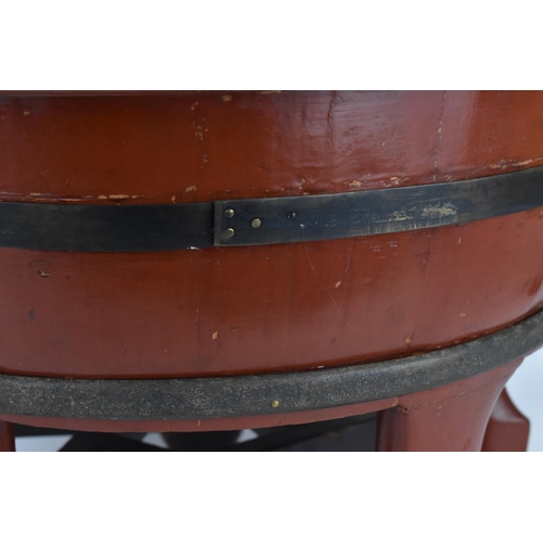 68 - A large Japanese red lacquer barrel planter, of circular form with brass band, supported on five fee... 