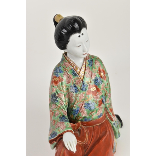 83 - A Japanese kutani porcelain model of a geisha, early 20th century, raised on a wooden stand, the fig... 