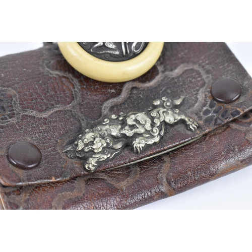 23 - A Japanese Meiji period tobacco sagemono (pouch) made from leather, with white metal foo dogs to the... 