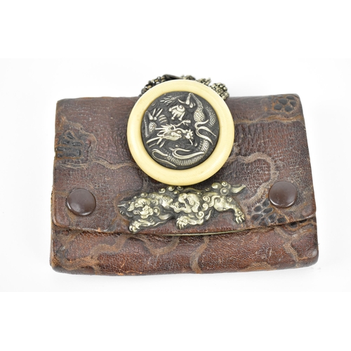 23 - A Japanese Meiji period tobacco sagemono (pouch) made from leather, with white metal foo dogs to the... 