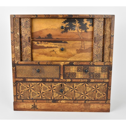 43 - A Japanese Meiji period miniature tansu parquetry cabinet, with tambour sliding front doors revealin... 