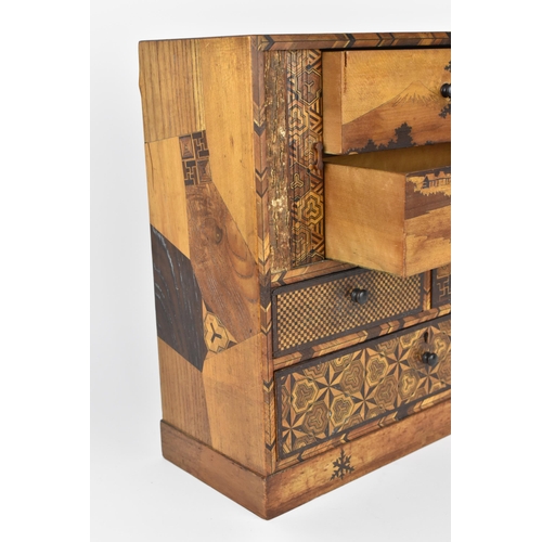 43 - A Japanese Meiji period miniature tansu parquetry cabinet, with tambour sliding front doors revealin... 