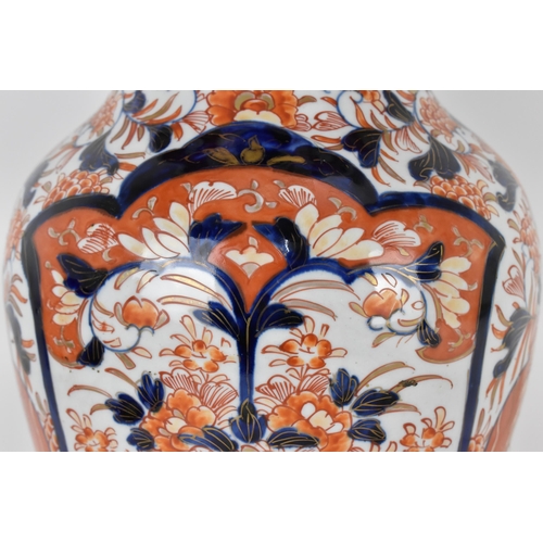 44 - A Japanese Imari porcelain baluster vase, with everted rim, the body decorated with two large panels... 