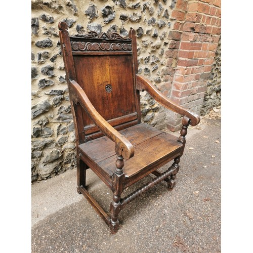 266 - An 18th century carved oak wainscott armchair, the back panel carved with central patera, supported ... 