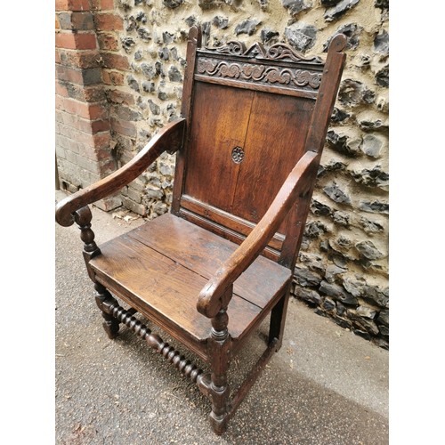 266 - An 18th century carved oak wainscott armchair, the back panel carved with central patera, supported ... 