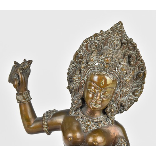 89 - A 19th century or earlier Nepalese bronze sculpture of the deity Vajravarahi, the goddess holding ri... 