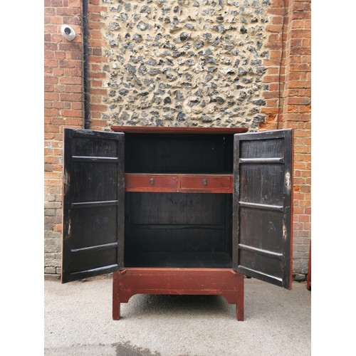 63 - A large Chinese red lacquer wedding cabinet, with moon lock to the central doors enclosing two drawe... 