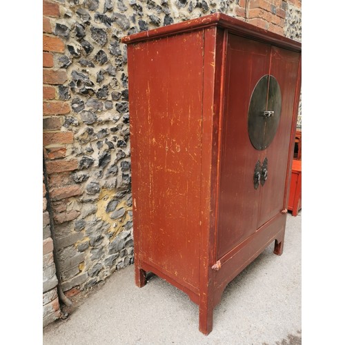 63 - A large Chinese red lacquer wedding cabinet, with moon lock to the central doors enclosing two drawe... 