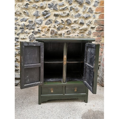 64 - A 20th century Chinese green lacquer cabinet, of rectangular form with twin doors enclosing one shel... 