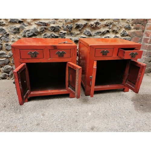 66 - A pair of Chinese red lacquer bedside cabinets, early 20th century, of square form with two small to... 