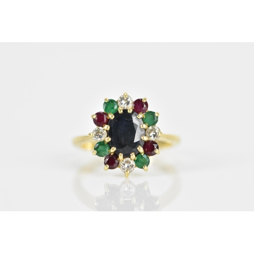 238 - An 18ct yellow gold, diamond, emerald, and ruby dress ring, with central twelve claw set oval cut da... 