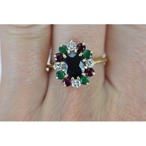 238 - An 18ct yellow gold, diamond, emerald, and ruby dress ring, with central twelve claw set oval cut da... 