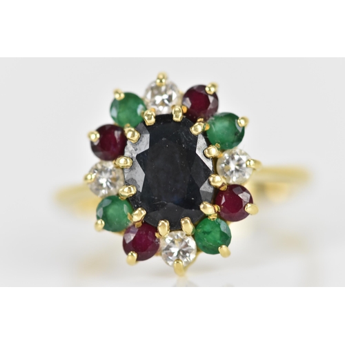 238 - An 18ct yellow gold, diamond, emerald, and ruby dress ring, with central twelve claw set oval cut da... 