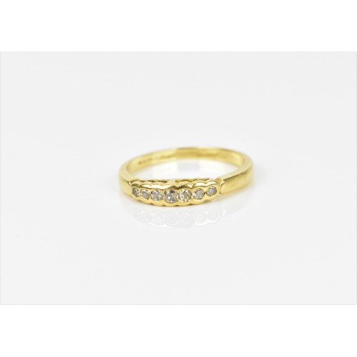 239 - An 18ct yellow gold and diamond ring, with a graduated row of seven bezel set round cut diamonds, st... 