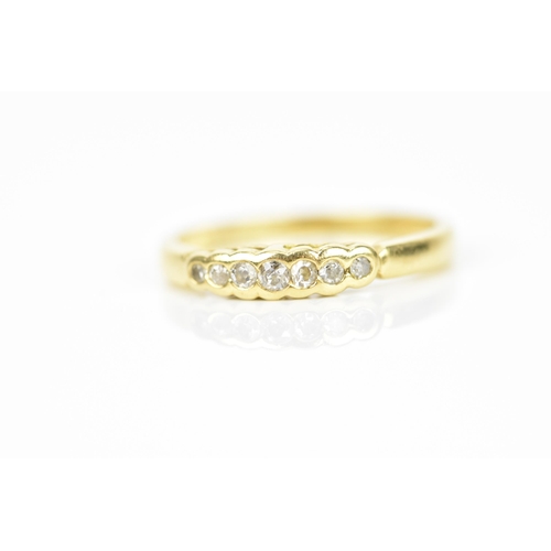 239 - An 18ct yellow gold and diamond ring, with a graduated row of seven bezel set round cut diamonds, st... 