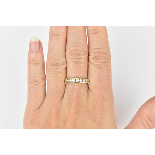 240 - An 18ct yellow gold and diamond half eternity ring, with seven channel set round brilliant cut diamo... 