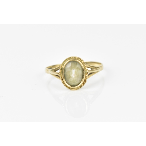 241 - A 9ct yellow gold and clear stone dress ring, with central rub over set oval cut stone, possibly fad... 