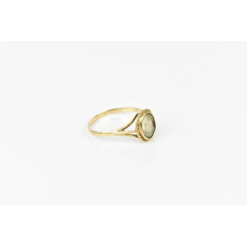 241 - A 9ct yellow gold and clear stone dress ring, with central rub over set oval cut stone, possibly fad... 