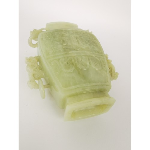 73 - A Chinese celadon jade taotie vase, of tapered form with dragon handles and hanging hoops, the front... 