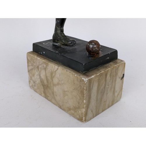 82 - An early mid 20th century patinated spelter football trophy fashioned as a footballer about to strik... 