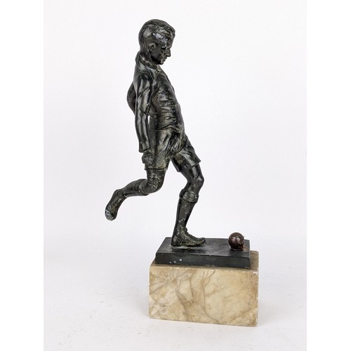 82 - An early mid 20th century patinated spelter football trophy fashioned as a footballer about to strik... 