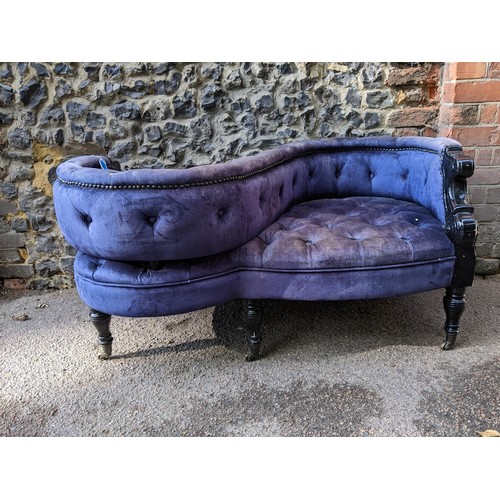 3 - A late 20th century love seat with a black glass finished framed, button upholstered in a blue velve... 