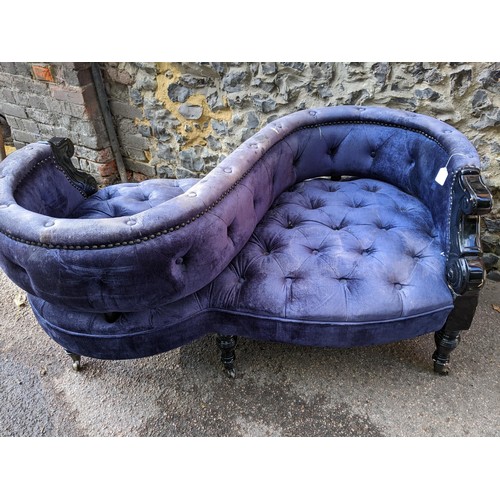 3 - A late 20th century love seat with a black glass finished framed, button upholstered in a blue velve... 