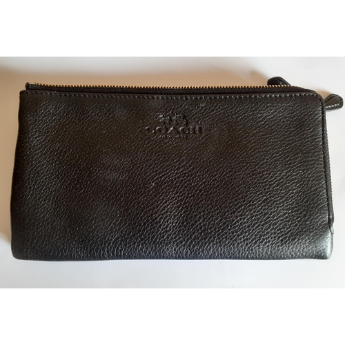 11 - Coach-A black soft leather double zip wallet minus detachable wrist strap, having a black zip and in... 