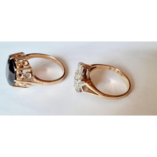 119 - Two 9ct gold dress rings, one set with white cabochons and the other with a large garnet, total weig... 