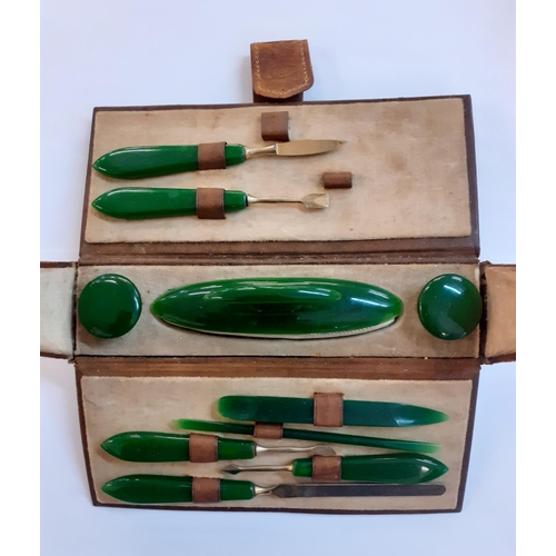 50 - An early 20th Century manicure set with green bakerlite handles housed in a brown leather case.Locat... 