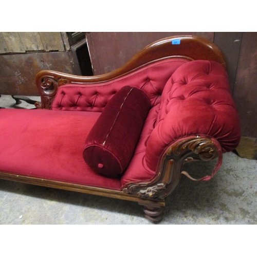 251 - A Victorian mahogany chaise longue with carved decoration, upholstered in a red dralon, on turned le... 