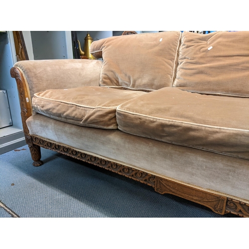 276 - An early 20th century three-seater sofa having an oak carved frame decorated with acanthus leaves an... 