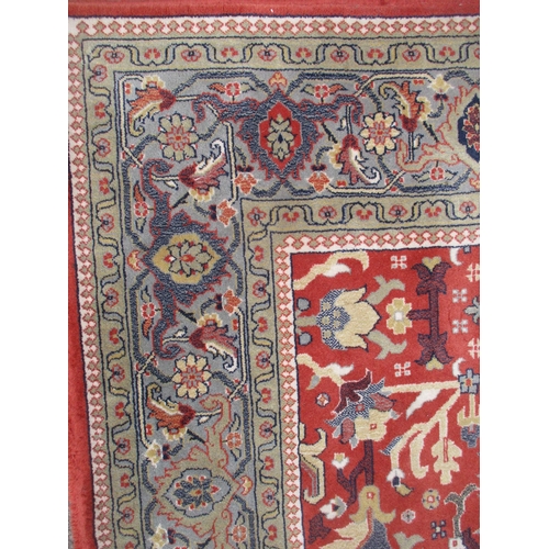 142 - A Delphi, Belgium, New Zealand wool rug, machine woven with floral design on a red ground, multiguar... 