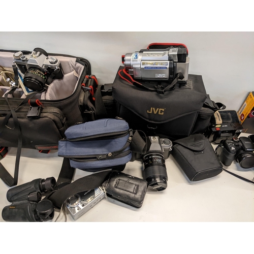 18 - A selection of cameras and accessories to include a Canon AE-I, Fujifilm S1000, JVC video camera and... 