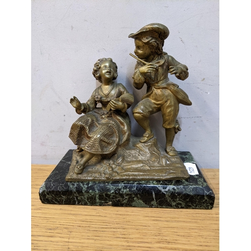 181 - An early 20th century French coast metal model of two children, one reading, and the other playing a... 