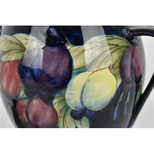 11 - An early 20th century William Moorcroft pottery twin-handled lidded pot, in the 'Plum and Wisteria' ... 