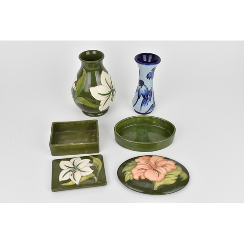 14 - A small collection of Moorcroft pottery to include two vases and two lidded boxes, in the Magnolia, ... 