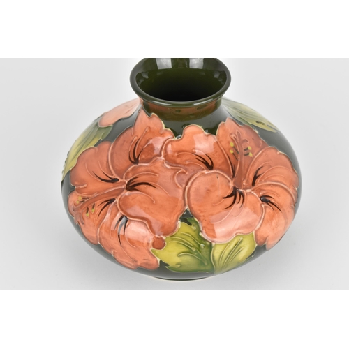 16 - A Walter Moorcroft pottery squat vase, in the 'Hibiscus' pattern, with pink blooms on a green ground... 