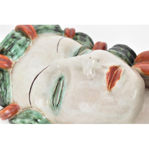 20 - An Art Deco period Goldscheider pottery mask, model no.6305, modelled as a lady with green curled ha... 