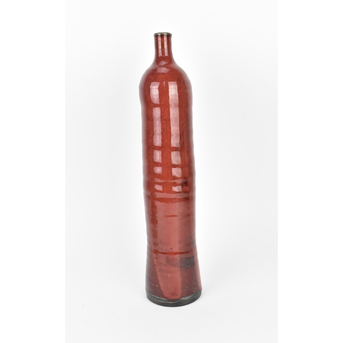 87 - A 20th century European studio pottery bottle vase, in a red mottled glaze with ribbed body, 38.5 cm... 