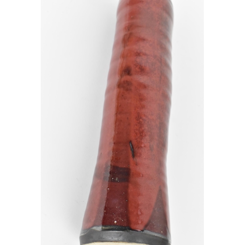 87 - A 20th century European studio pottery bottle vase, in a red mottled glaze with ribbed body, 38.5 cm... 