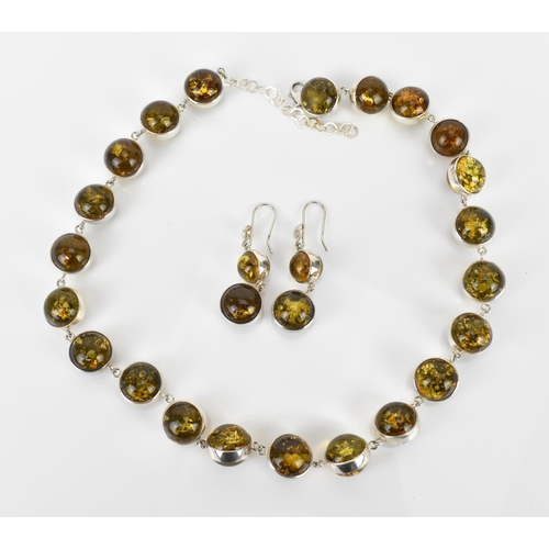 155 - A silver and green amber bead necklace with matching earrings, the amber beads with silver surround,... 