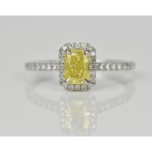 181 - A fancy intense yellow diamond and diamond cluster ring, the cut corner rectangular modern brilliant... 