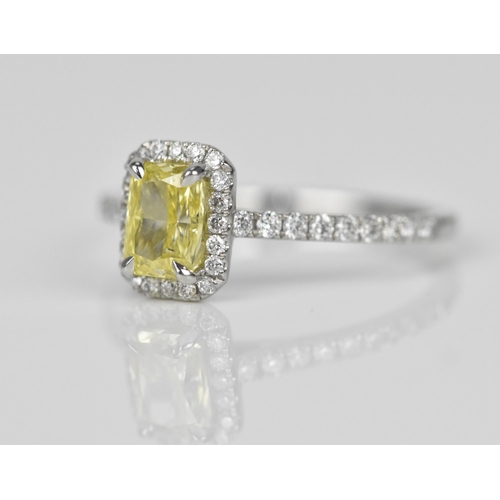 181 - A fancy intense yellow diamond and diamond cluster ring, the cut corner rectangular modern brilliant... 